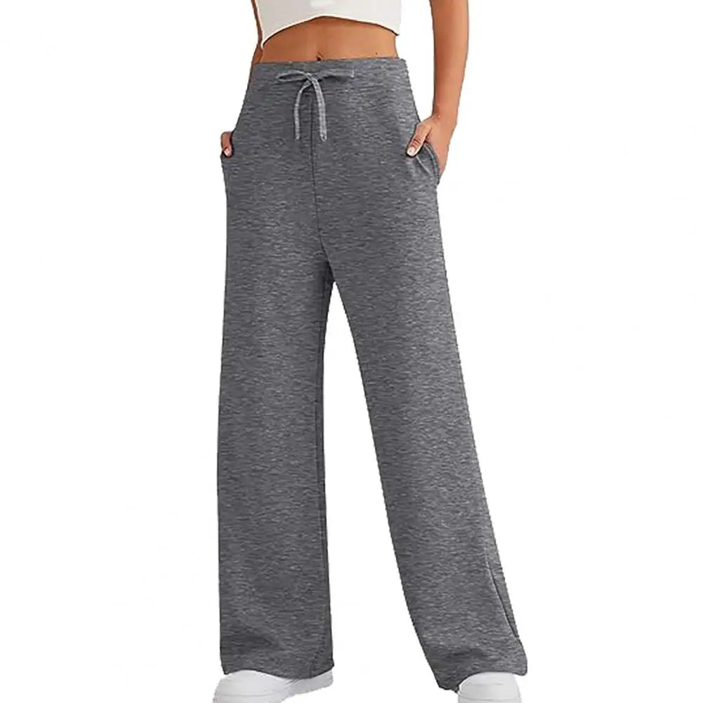 Pantalon ample femme gris foncé avec taille haute et coupe évasée.
